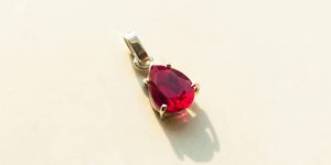 a red heart shaped pendant sitting on top of a table